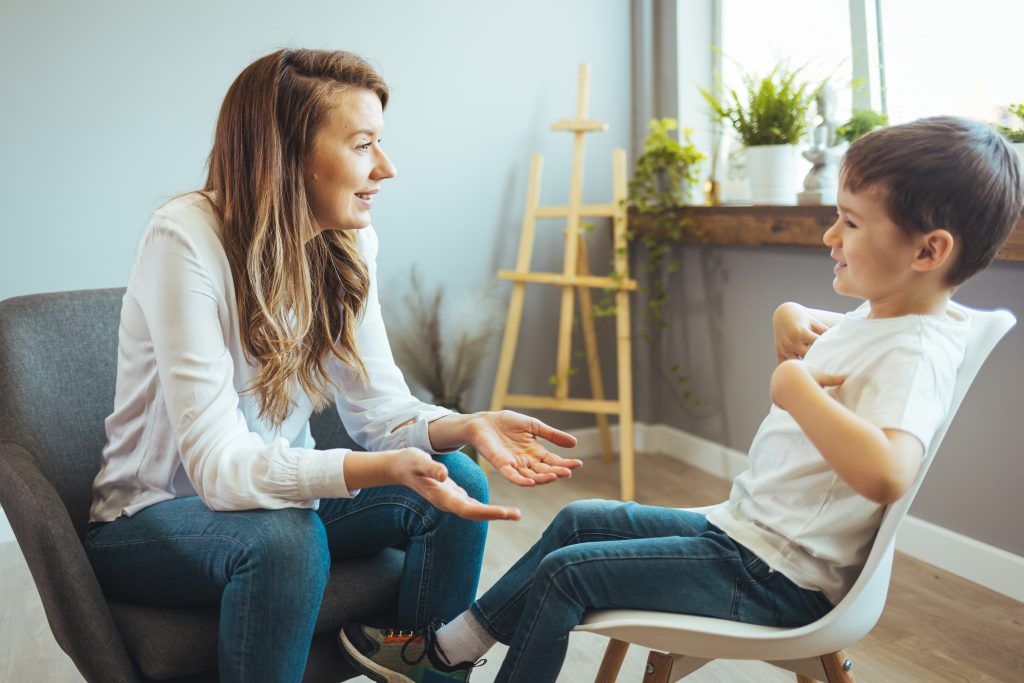 Cheerful,Young,Kid,Talking,With,Helpful,Child,Counselor,During,Psychotherapy